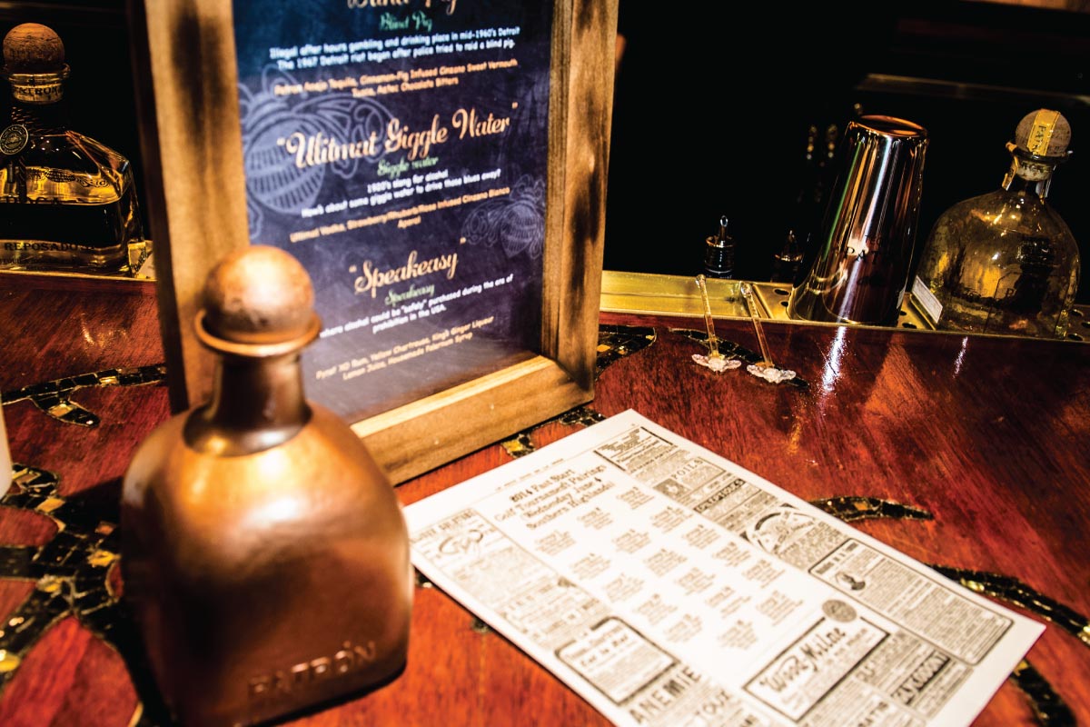 custom made bar menu and decorations on top of bar with gold patron bottle